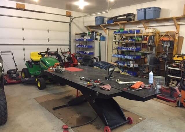 Cranbury Equipment Repair workshop with a workbench, tools and lawn equipment